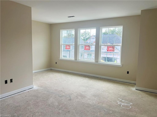 spare room featuring a healthy amount of sunlight, visible vents, and baseboards