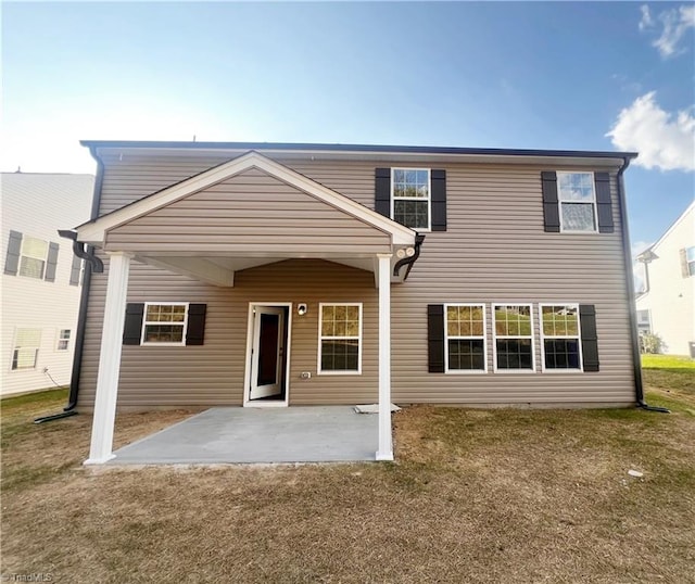 rear view of house featuring a patio and a lawn