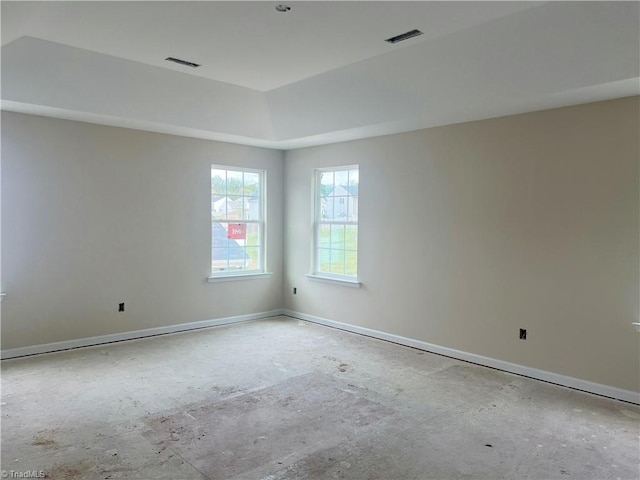 spare room featuring visible vents, a tray ceiling, and baseboards