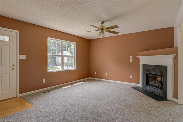 261 Williamsgate Ct, Winston-Salem, NC 27107 - unfurnished living room with carpet flooring, ceiling fan, a fireplace with flush hearth, a textured ceiling, and baseboards