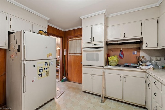 kitchen with white appliances, light floors, light countertops, under cabinet range hood, and crown molding