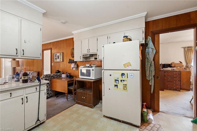 kitchen featuring wooden walls, light floors, white appliances, and crown molding