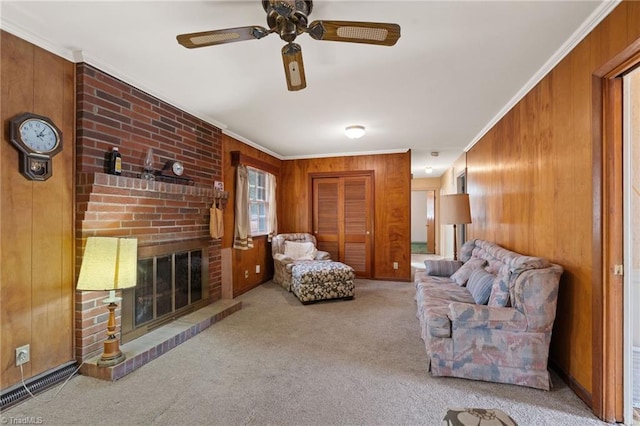 carpeted living room with wood walls, a fireplace, ceiling fan, and ornamental molding