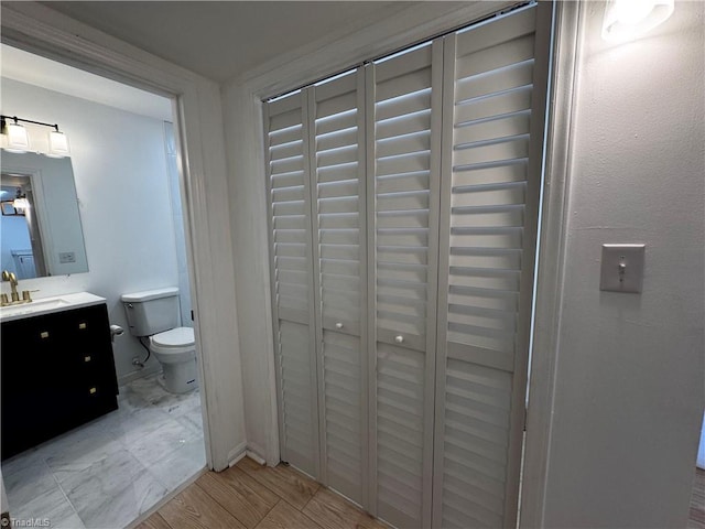 bathroom with vanity, toilet, and wood-type flooring