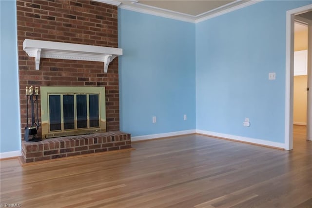 unfurnished living room featuring hardwood / wood-style floors, ornamental molding, and a brick fireplace