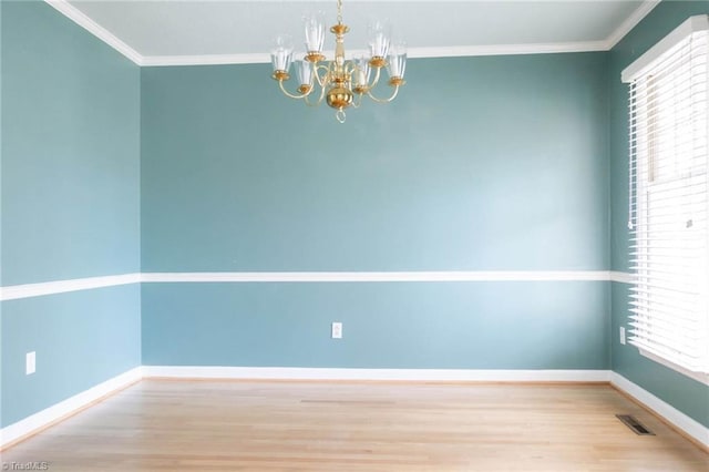 spare room featuring hardwood / wood-style floors, plenty of natural light, and ornamental molding