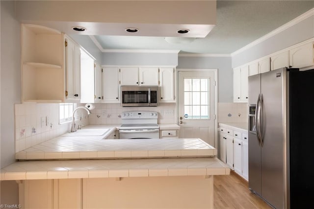 kitchen featuring tile countertops, stainless steel appliances, and kitchen peninsula