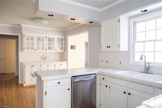 kitchen featuring sink, tile countertops, dishwasher, kitchen peninsula, and white cabinets