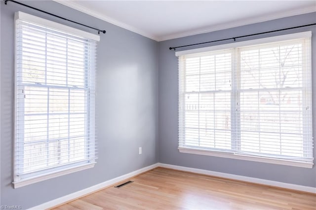 empty room featuring crown molding and light hardwood / wood-style floors