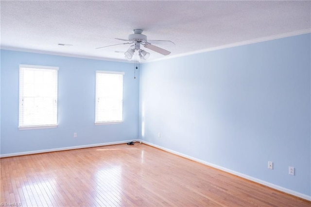 empty room with ceiling fan, ornamental molding, light hardwood / wood-style flooring, and a textured ceiling