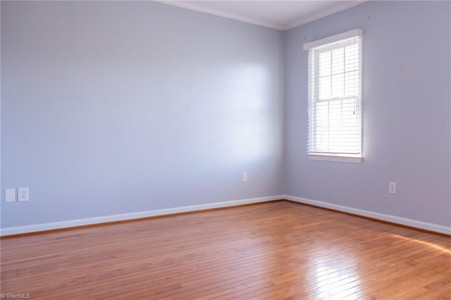 spare room with crown molding and light hardwood / wood-style flooring