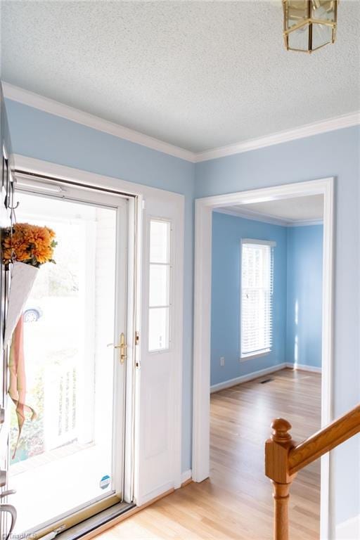 entrance foyer featuring crown molding, light hardwood / wood-style flooring, and a textured ceiling