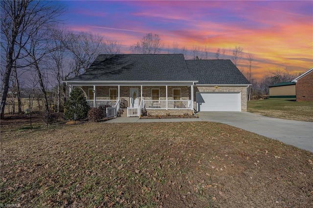 view of front of property featuring a yard, a porch, and a garage