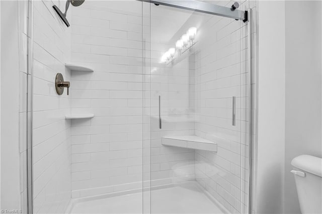 bathroom featuring an enclosed shower and toilet