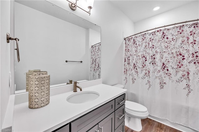 bathroom featuring vanity, hardwood / wood-style flooring, and toilet