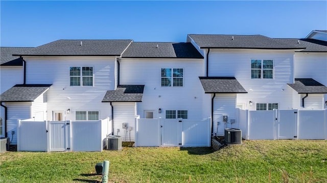 rear view of house featuring a lawn and cooling unit