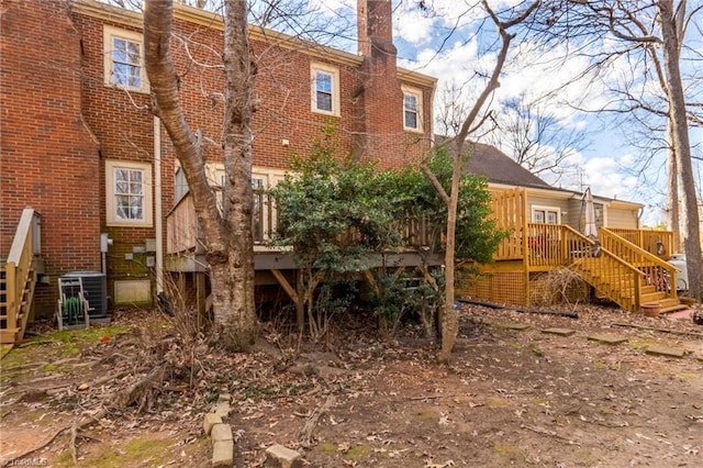 rear view of property featuring cooling unit and a deck