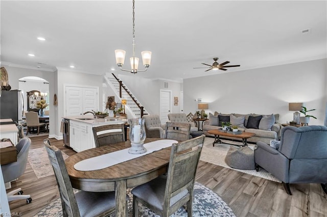 dining area with recessed lighting, arched walkways, stairway, ceiling fan with notable chandelier, and visible vents