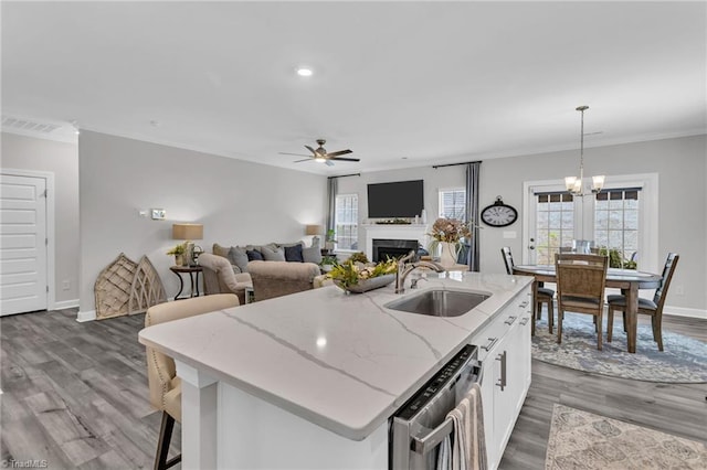 kitchen featuring dishwasher, ceiling fan with notable chandelier, crown molding, and a sink