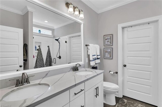 bathroom with toilet, crown molding, a stall shower, and a sink