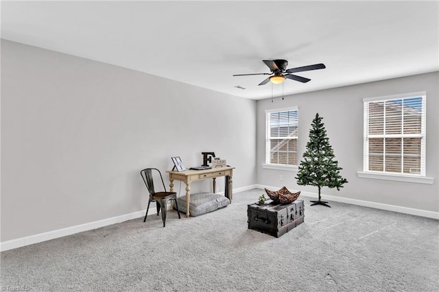 living area featuring a ceiling fan, carpet, and baseboards