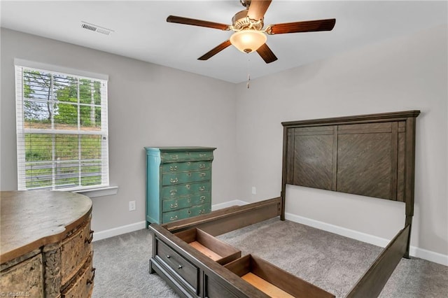 carpeted bedroom featuring a ceiling fan, visible vents, and baseboards