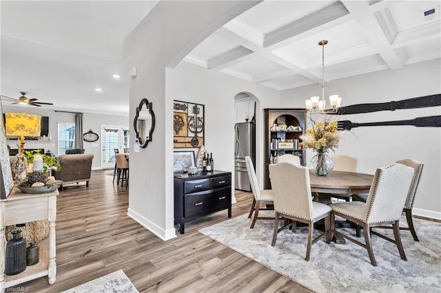 dining space with recessed lighting, arched walkways, ceiling fan with notable chandelier, light wood finished floors, and beam ceiling