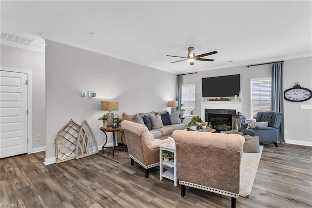 living room featuring a ceiling fan, visible vents, wood finished floors, and a healthy amount of sunlight