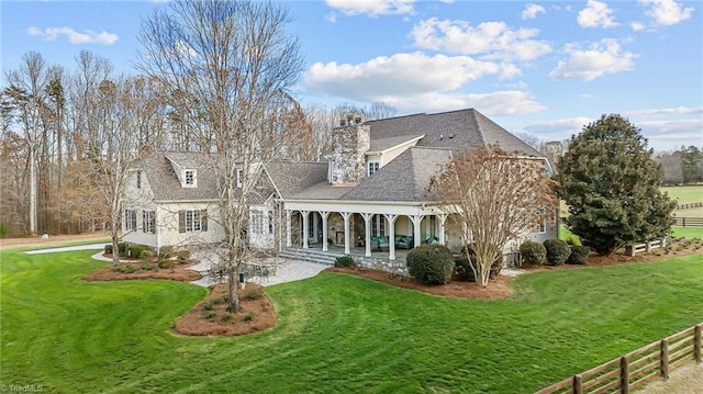 rear view of house with a porch and a lawn