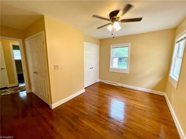 unfurnished bedroom with ceiling fan and dark hardwood / wood-style flooring