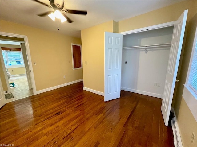 unfurnished bedroom featuring dark wood-type flooring, a closet, ceiling fan, and baseboard heating