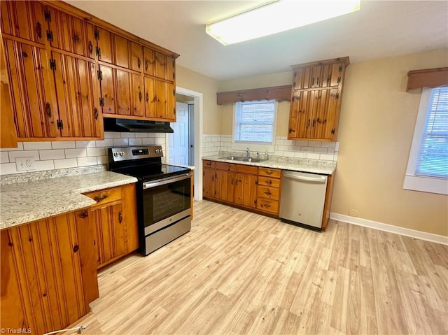 kitchen with tasteful backsplash, sink, light hardwood / wood-style floors, and appliances with stainless steel finishes