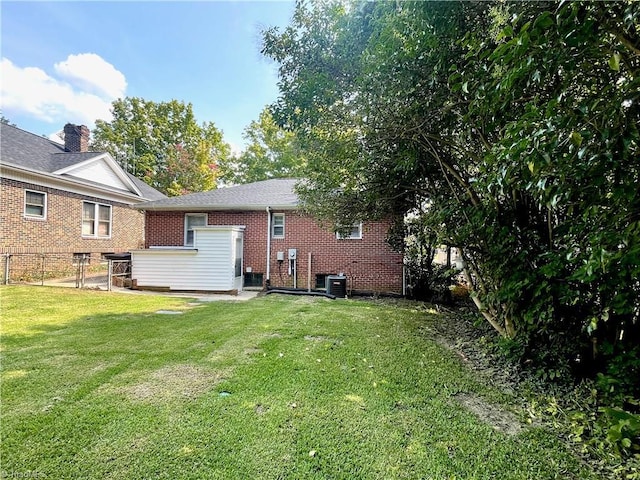 back of house featuring a yard and central AC unit