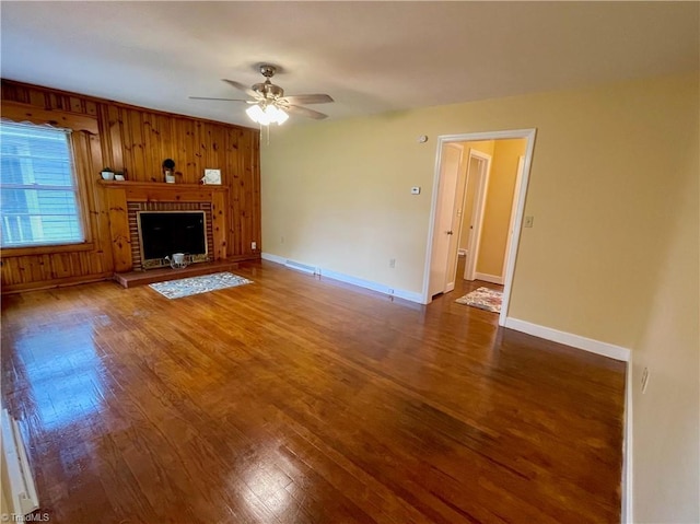 unfurnished living room with a brick fireplace, hardwood / wood-style flooring, and ceiling fan