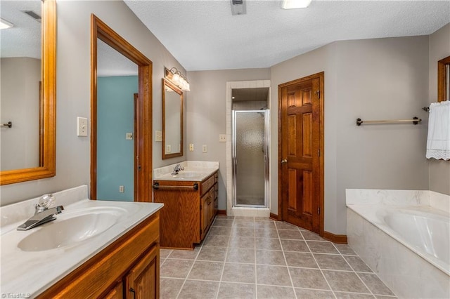 full bath with a shower stall, a textured ceiling, tile patterned flooring, a garden tub, and two vanities