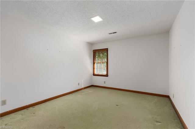 carpeted spare room with a textured ceiling and baseboards