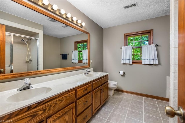 bathroom featuring plenty of natural light, a stall shower, baseboards, toilet, and a textured ceiling