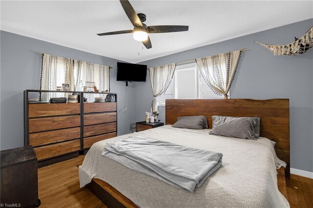 bedroom with hardwood / wood-style flooring and ceiling fan