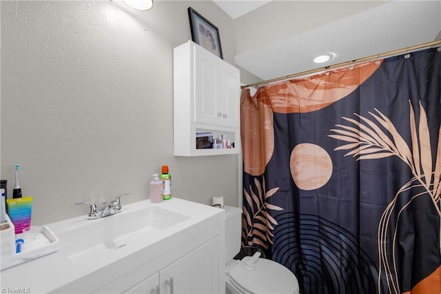 bathroom with a shower with curtain, vanity, and toilet