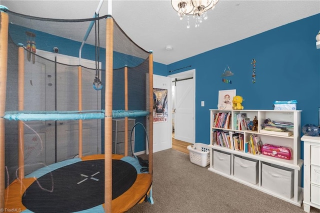 carpeted bedroom with an inviting chandelier and a barn door