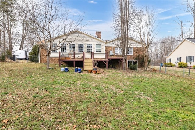 rear view of property featuring a wooden deck and a lawn