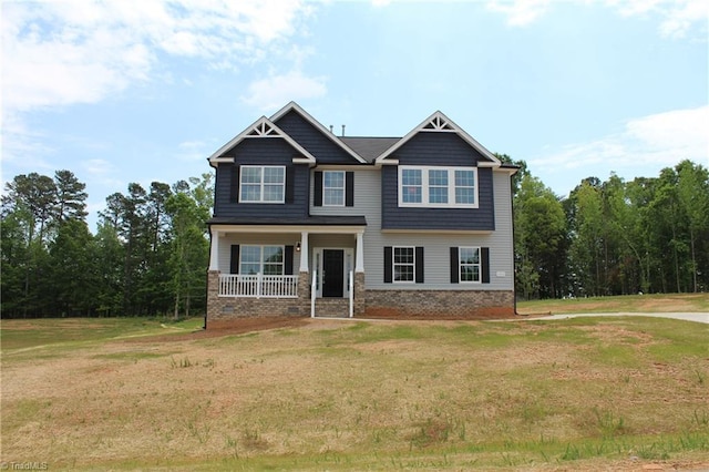 craftsman-style house featuring covered porch and a front yard