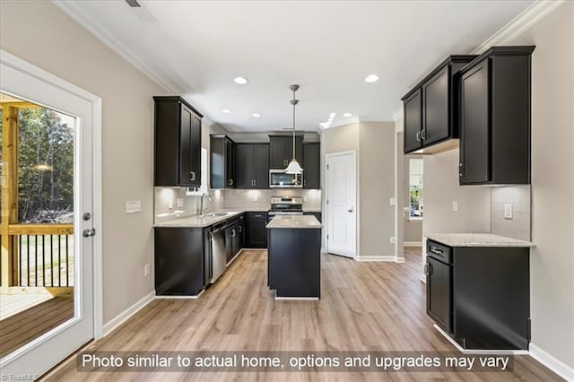 kitchen featuring backsplash, a center island, a sink, light wood-style floors, and stainless steel appliances
