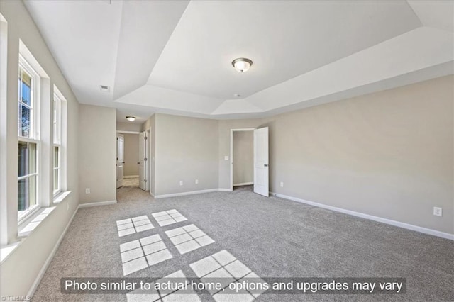 unfurnished room featuring carpet floors, baseboards, and a tray ceiling