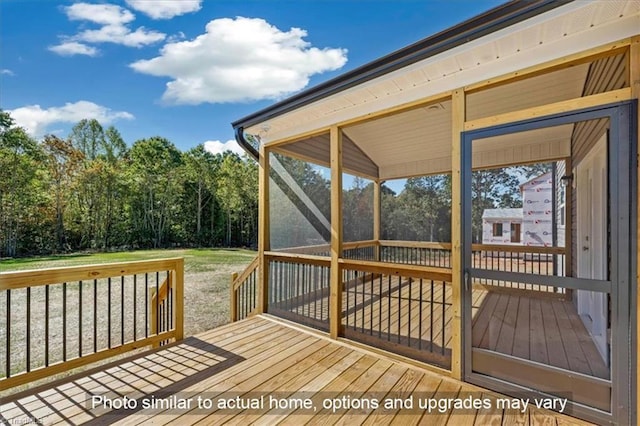 wooden terrace with a sunroom and a lawn