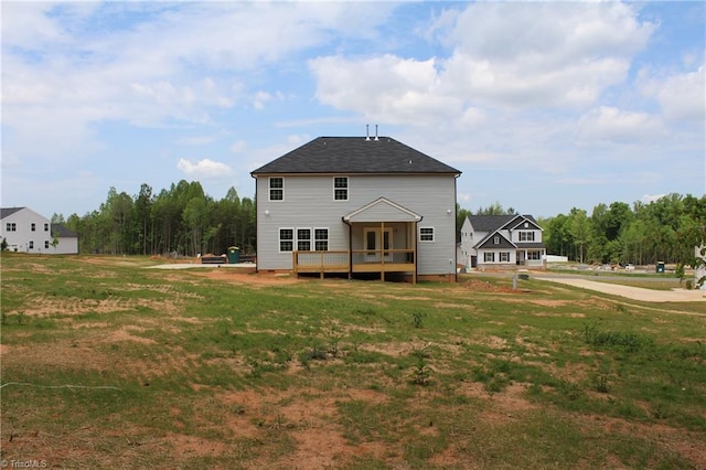 back of house featuring a lawn and a wooden deck