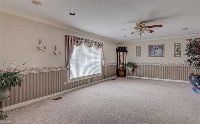 empty room with carpet, a textured ceiling, ornamental molding, and ceiling fan