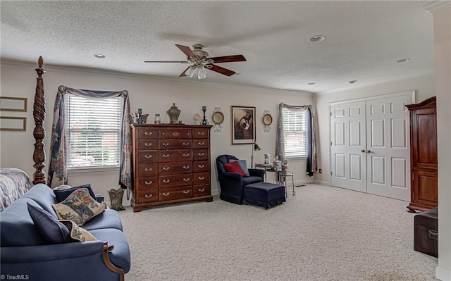 carpeted living room featuring crown molding, a textured ceiling, and ceiling fan