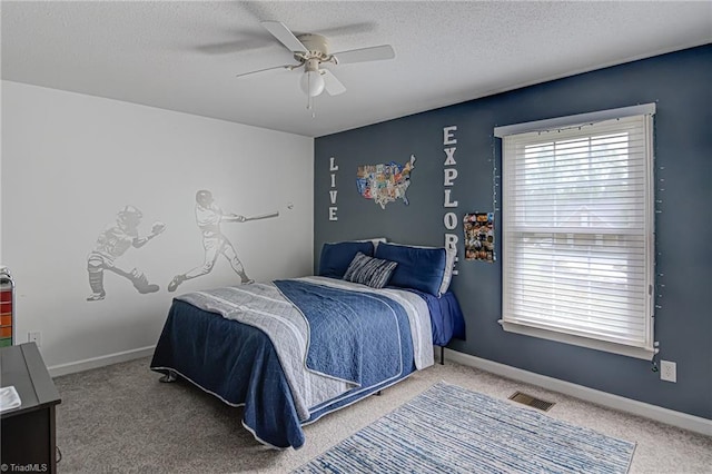 carpeted bedroom with a textured ceiling and ceiling fan