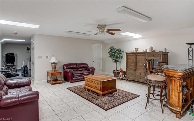 tiled living room with a skylight and ceiling fan